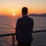 lucid-origin_man_standing_balcony_ocean_horizon_sunrise_suit-4