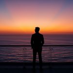lucid-origin_man_standing_balcony_ocean_horizon_sunrise_suit-5