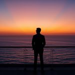 lucid-origin_man_standing_balcony_ocean_horizon_sunrise_suit-5